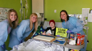 Elizabeth (in blond hair) visits a Camp Happy Days patient with her colleagues. 