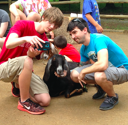 TCS student and teacher working with goats at the zoo.